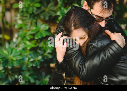 Paar in der Liebe mit gelöster Probleme, Freund Konsolen seine Freundin von ihr umarmen. Stockfoto