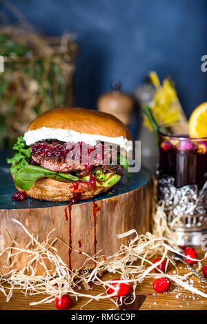 Gegrilltes Rindfleisch Burger mit Salat und Pilze auf einem rustikalen Holztisch von Zähler serviert, mit Copyspace. Stockfoto