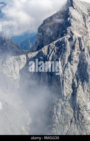 Die Jalovec Bergrücken in Wolken, Teil der Julischen Alpen, während ein Klettersteig Klettertour im Sommer. Stockfoto