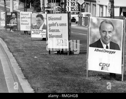 Dieses Foto zeigt einen grünen Streifen, wo in der ersten Position im Vordergrund montiert sind Wahlplakate der FDP und CDU.: Ein Wahlplakat der CDU, es wirbt mit dem Porträt von Alfred Dregger und der Slogan 'CDU, Safe, sozialen und freien", hinter der FDP mit dem Appell "Es ist Alles oder Nichts jetzt, FDP die Liberalen", dahinter ist ein wahlplakat der CDU, die sich mit dem Porträt des Kanzlerkandidaten der Union Franz-Josef Strauss und das Versprechen "Franz Josef Strauss Bundeskanzler für Frieden und Freiheit' und 'CDU sicher, sozialen und freien", hinter Stockfoto