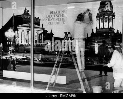 Ein Mann auf der Schaufenstergestaltung zur Feier des 40. Jahrestages der DDR arbeiten. 40-jähriges Jubiläum der Stiftung 07.10.1989, Politik, Deutschland 1949-1990, DDR Stockfoto