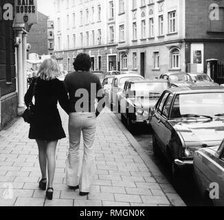 Ein paar Spaziergänge entlang einer Straße im Stadtteil Schwabing, München. Stockfoto
