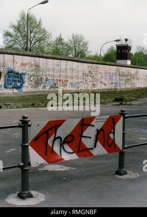 Blick auf einen Teil der Graffiti - Berliner Mauer in der Nähe von Brandenburger Tor, dahinter ein Wachturm der DDR an. Stockfoto