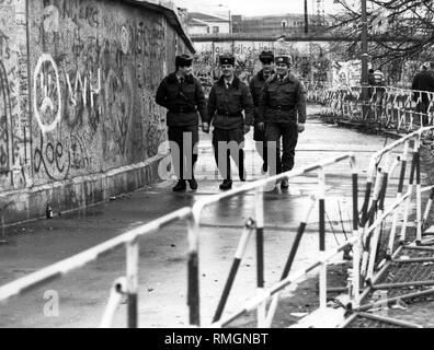 Grenzsoldaten der DDR führen ein Border Patrol auch nach der Öffnung der Berliner Mauer auf der Westseite des noch stehenden Wand. Stockfoto