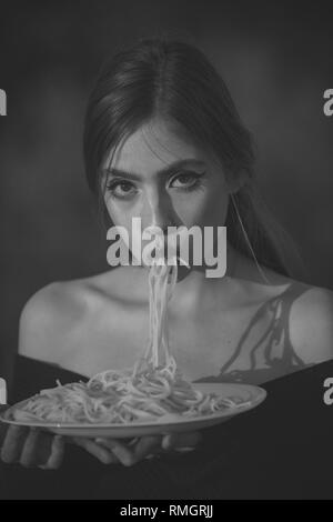 Hunger, Appetit, Rezept. Italienische Nudeln oder Spaghetti zum Abendessen kochen. Diät und gesunde Lebensmittel aus biologischem Anbau, Italien. Koch Frau mit roten Lippen essen Pasta Stockfoto