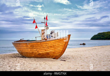 Altes, hölzernes Fischerboot auf Sandstrand im Ostseebad Binz. Insel Rügen, Deutschland Stockfoto