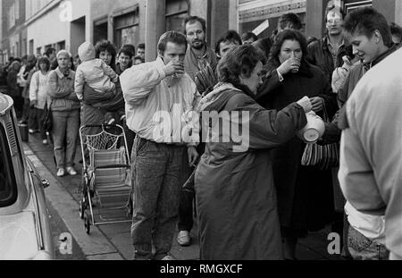 Nach der Öffnung der Berliner Mauer am 9. November, DDR-Bürger warten auf Ihr Visum in die Bundesrepublik Deutschland bei der Registration Office in Muenzstrasse. Sie sind mit warmen Getränken während der Wartezeit. Stockfoto