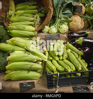 Grüne Lebensmittel einschließlich Zucchini, Auberginen, Spargel, Paprika und Brokkoli auf Verkauf zu einem Gemüse in einem lokalen Landwirt Marktstand. Stockfoto