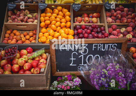 Vielfalt organischer frisches Obst wie Orangen, Äpfel und Pfirsiche auf Verkauf zu einem in einem lokalen Landwirt Marktstand. Saisonale Produkte. Querformat. Stockfoto