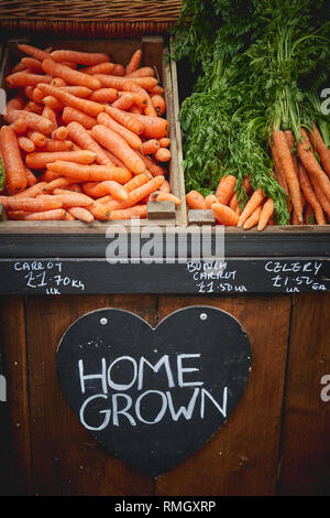 Bio Gemüse wie Karotten, Brokkoli und Bohnen auf Verkauf in einem Stall in einem lokalen Bauernmarkt. Hochformat. Stockfoto