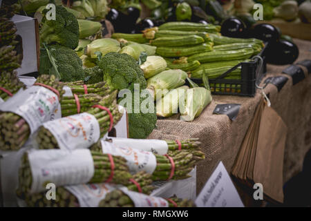 London, UK - Juni, 2018. Grüne Lebensmittel einschließlich Zucchini, Auberginen, Spargel, Paprika und Brokkoli auf Verkauf zu einem Gemüse in einem Marktstand. Stockfoto