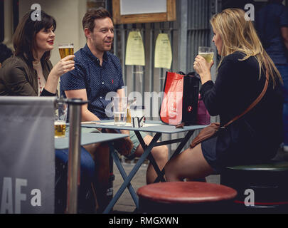 London, UK - Juni, 2018. Junge Menschen genießen Getränke außerhalb einer Kneipe Restaurant in Borough Market. Stockfoto