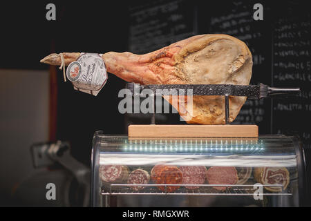 London, UK - Juni, 2018. Eine ganze italienische Parma Schinken auf einem Stand aus Holz mit anderen Salami und Wurst auf Anzeige in einer in Borough Market Stall. Stockfoto