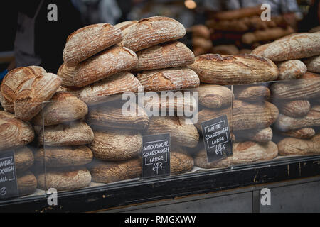 Stapel von organischen braunen und weißen Sauerteigbrot Brote auf den Verkauf in einem lokalen Bauernmarkt. Querformat. Stockfoto