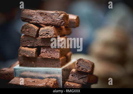 Stapel von chocolate Brownies mit einem unscharfen Hintergrund auf den Verkauf in einer Bäckerei in einem Lebensmittelmarkt. Querformat. Stockfoto