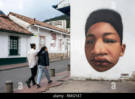 Einheimische wandern vorbei an bunten Wand Graffiti in La Candelaria, Bogota, Kolumbien. Credit: BiP (American Graffiti Artist) BiPgraffiti.com - Sep 2018 Stockfoto