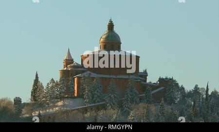 In der Nähe von San Luca Heiligtum im Schnee, in der Dämmerung im Winter. Sonne auf Hügeln von Bologna in Italien. Stockfoto