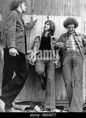 Drei Jugendliche, das Tragen von Bell Bottoms, Lean gegen eine Holzwand. Stockfoto