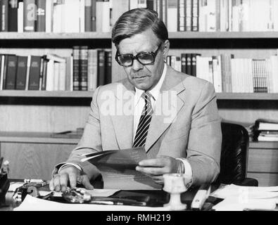 Bundeskanzler Helmut Schmidt geht durch einige Papiere an seinem Schreibtisch in der Bonner neue Bundeskanzleramt. Stockfoto