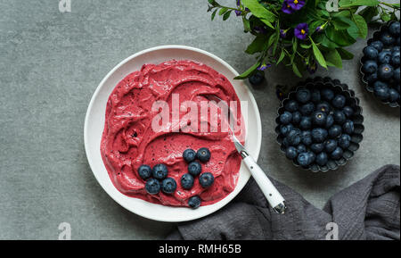 Smoothy von frischen Heidelbeeren und Himbeeren in der Schüssel in der Nähe von Serviette bog Stockfoto