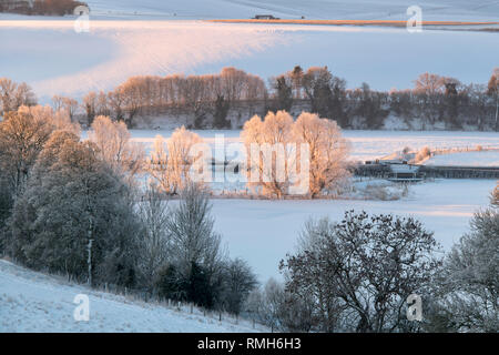 Verschneite Winterlandschaft bei Sonnenaufgang in Avebury, Wiltshire, England Stockfoto