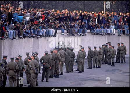 Berlin, 10. November 1989: Tausende Berliner versammeln sich auf der Berliner Mauer am Brandenburger Tor. Ddr-Grenztruppen verhindern, Menschen die Einreise in das Sperrgebiet. Stockfoto