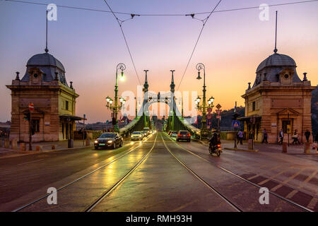 Autos fahren über die Brücke in Budapest in der Dämmerung Stockfoto