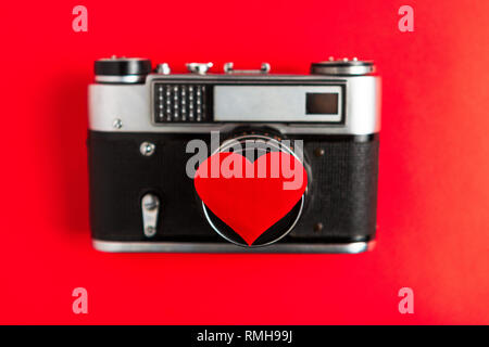 Alte vintage Foto Kamera mit roten Herzen auf. roten Hintergrund. für Dekor und Design. Valentinstag Grußkarte. Konzept Liebe und Romantik auf Fotografien. Stockfoto