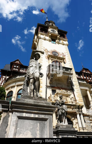 Der Glockenturm mit der nationalen Flagge gegen den blauen Himmel im königlichen Schloss Peles in Rumänien. Stockfoto