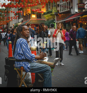 London, UK - Februar, 2019. Straßenmusiker Schlagzeug spielen während einer Performance in Chinatown. Stockfoto