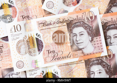 Zehn Pfund Noten, England. UK Währung Bargeld GBP Bank Note mit einem Penny Münze 1 s. Stockfoto