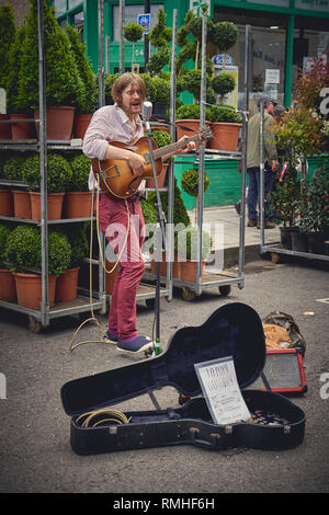 London, UK, 2018. Eine junge Straße Gitarrist durchführen an den Columbia Road Blumenmarkt. Stockfoto