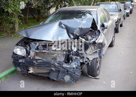 Pkw mit kaputten Haube und Motor Abschnitt Aufenthalt ist unter anderem Autos am Strassenrand Stockfoto