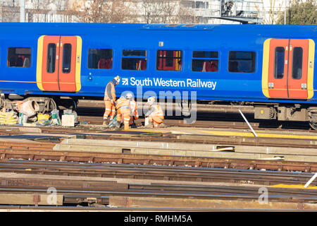 Clapham Junction, London, UK, 14. Februar 2019; Gruppe der Eisenbahner, die Strecke mit dem Zug hinter Stockfoto