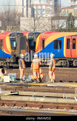 Clapham Junction, London, UK, 14. Februar 2019; Gruppe der Eisenbahner, die Strecke mit dem Zug hinter Stockfoto