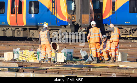 Clapham Junction, London, UK, 14. Februar 2019; Gruppe der Eisenbahner, die Strecke mit dem Zug hinter Stockfoto