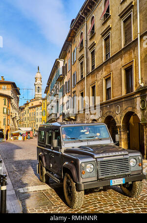 Ein off-road Kreuzung Largo Cinque Vie Straße mit dem Glockenturm der Basilika St. Alexander in Spalte im Hintergrund, in Bergamo, Bergamo Stockfoto