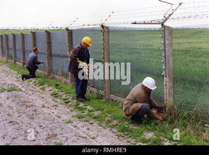 In der Nähe von Helmstedt, die Bauarbeiter der grenzbefestigung an der innerdeutsche Grenze abzubauen, hier bei einem elektrischen Zaun. Stockfoto