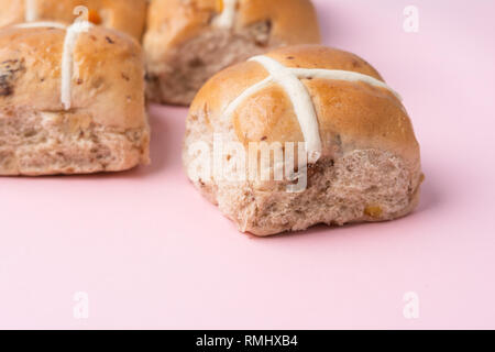 Hot Cross Buns, traditionelle britische Kulinarische Ostern auf rosa Hintergrund, selektiver Fokus Stockfoto