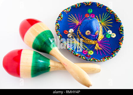 Blau sombrero mit bunten Ornamenten auf weissem Hintergrund neben Paar maracas schmerzte, mit den Farben der Mexikanischen Flagge / Cinco de Mayo Konzept Stockfoto