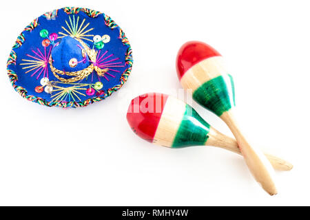 Blau sombrero mit bunten Ornamenten auf weissem Hintergrund neben Paar maracas schmerzte, mit den Farben der Mexikanischen Flagge / Cinco de Mayo Konzept Stockfoto
