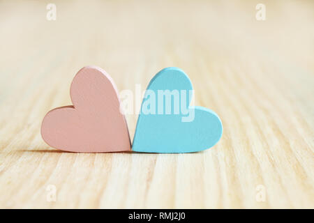 Rosa und Hellblau Holz- Herzen auf Holzbrett Stockfoto