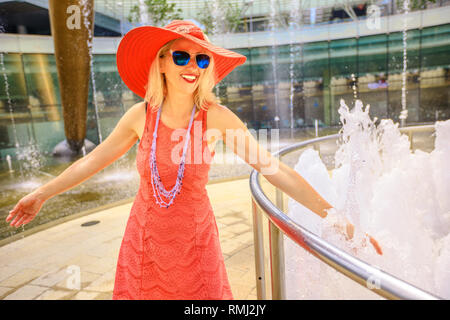 Fontäne des Reichtums an Suntec Tower, der größte Brunnen in Singapur. Lifestyle Frau gehen und berühren Sie Wasser der Brunnen Glück zu erhalten. Blond kaukasischen Stockfoto