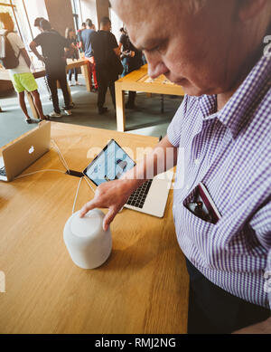 Straßburg, Frankreich - 21.September 2018: Neugierig älterer Mann testen HomePod der smart Lautsprecher im Apple Store mit Kunden im Hintergrund Stockfoto