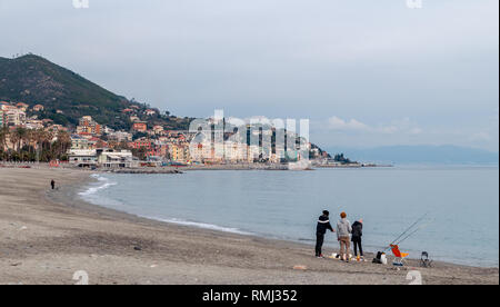 Junge Fischer am Strand. Im Hintergrund die Stadt von Varazze. Bewölkter Himmel Stockfoto