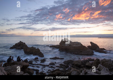 Zwei Fotografen sitzen auf den Felsen der kleine Corona Beach in Südkalifornien Stockfoto