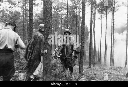 Unteroffiziere der Luftwaffe in einem Wald im Bereich Schulungen von Sagan in Oberschlesien. Die Soldaten tragen ihre Unterkunft - die Hälfte für Tarnung und als Schutz vor Regen. Sie tragen einen Mg-13 Maschinengewehr. Die Männer sind wahrscheinlich an einer Infanterie Combat Training Course. Stockfoto