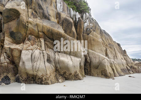 Erodiert Granit Bluffs steigen steil am Rand von einem Sandstrand auf der äußeren Ufer des CalvertIisland, an der British Columbia Central Coast. Stockfoto