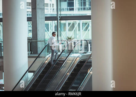 Aufsteigend Geschäftsmann Rolltreppe im Büro Stockfoto