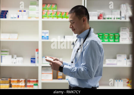 Jungen asiatischen männlicher Arzt holding Medizin und stehen in der Klinik Stockfoto